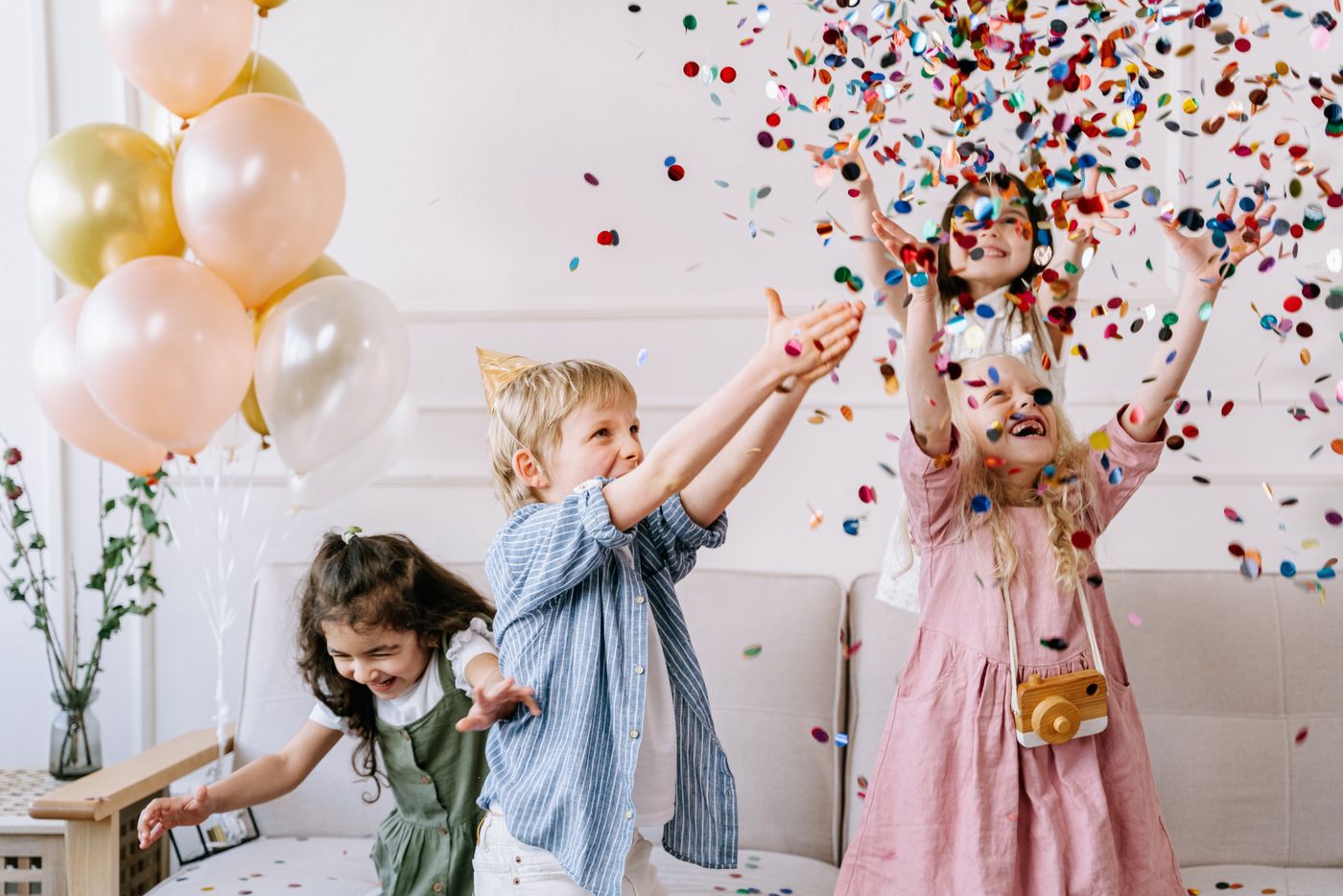 Children throwing colourful confetti at a party
